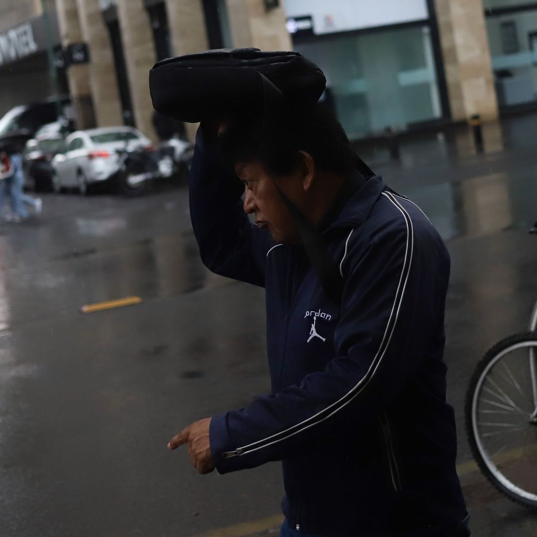 Ciudadano camina en la CDMX bajo la lluvia